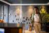 Confident business woman arriving in hotel lobby with luggage for business trip