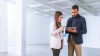 Two business colleagues looking at a tablet in an empty office